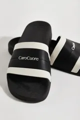 Sandalias de goma negras con banda ancha blanca con el logo de la marca.