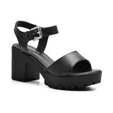 Sandalias negras con plataforma y taco ancho, tira ancha sobre los dedos y tira con hebilla alrededor del tobillo.
