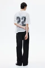 Pantalón de jean negro de corte holgado, con tiro bajo y cinco bolsillos.