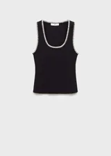 Musculosa negra de algodón con ribete blanco en cuello y sisas, corte ajustado y cuello redondo.