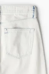Pantalón de jean de corte holgado, color blanco con efecto desteñido en azul. Diseño de cinco bolsillos y tiro bajo.