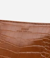 Bolso bandolera pequeño color marrón con textura de piel de cocodrilo, correa fina ajustable, cierre de cremallera y hebillas laterales decorativas.