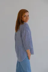 Blusa de mangas 3/4 con cuello en V y estampado a rayas verticales azules y blancas.