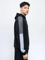 Buzo canguro gris con capucha, mangas ranglán celestes y detalles en blanco. Logo de Umbro bordado en el pecho.