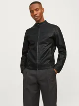 Chaqueta biker negra de cuero sintético con cierre de cremallera, cuello mao con botón a presión, detalles acolchados en los hombros, bolsillos laterales con cremallera, puños con cremallera y forro de poliéster reciclado.