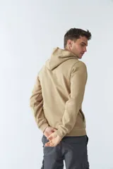 Buzo canguro color arena de felpa, con capucha ajustable, bolsillo tipo canguro, mangas largas y logo estampado en el pecho.