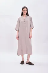 Vestido largo color visón con cuello solapado, manga corta y corte holgado.