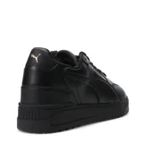 Championes urbanos Puma Shuffle Downtown, color blanco con detalles en negro y dorado, con logo Puma en el lateral y talón en contraste.