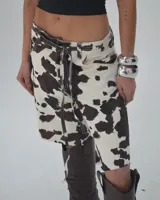 Bermuda de tiro alto con estampado de vaca en tonos marrón y blanco, con cordón ajustable en la cintura.