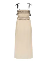 Vestido midi color arena con tirantes finos ajustables y detalle de borlas negras. Presenta un diseño smock en el corpiño y falda con caída fluida.