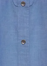 Camisa celeste de manga larga con puños abotonados, diseño recto, cierre delantero de botones a presión, cuello camisero, costuras decorativas, tachuelas decorativas y bordado decorativo.