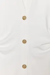 Vestido midi color gris topo, de cuello camisero y escote pico con manga corta. Tiene detalle de drapeado lateral y cierre frontal con botones metálicos.