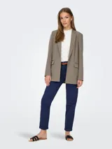 Blazer largo color marrón topo, de corte holgado y tejido sastrero con trama twill. Tiene cuello con solapa y bolsillos delanteros funcionales.
