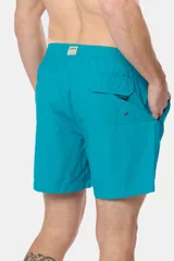Short de baño azul vibrante, de corte clásico y largo medio, con cintura elástica y cordón ajustable. Cuenta con bolsillos laterales y suspensor de malla fina interior.