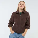 Sweater de punto marrón con cuello alto, cierre de cremallera metálica y mangas largas.