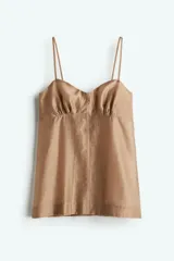 Top color beige de tejido transparente de mezcla de lyocell, con escote corazón, breteles finos ajustables y cierre oculto con cierre de corchete en la espalda. Presenta frunces abajo del busto y franjas verticales tono sobre tono.