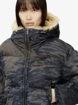 Chaqueta puffer con efecto de lavado tipo camuflaje en tonos azules y marrones. Presenta capucha con ribete de piel sintética, cierre frontal de cremallera y bolsillos laterales con cremallera.