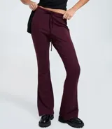 Pantalón de sastrería modelo flare en color beige, confeccionado en tejido de viscosa. Presenta un diseño de tiro alto con lazo ajustable en la cintura y detalle de friso vertical a lo largo de las piernas que estiliza la figura.