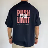Remera negra de corte amplio, con estampa en la espalda con la frase "Push Your Limit Since October 2023" en color rosa y blanco.