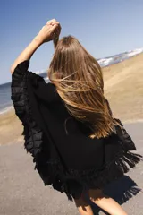 Ruana marrón tejida en lana merino con detalles de lino y flecos.