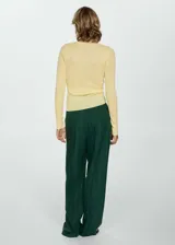 Remera de punto de canalé color amarillo pálido, de tejido fino, cuello redondo, diseño entallado y manga larga.