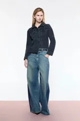 Campera de denim negra, fit entallado, con efecto desflecado en el ruedo y bordado en la espalda.