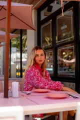 Camisa celeste con estampado de flores blancas, corte clásico, cuello camisero y mangas largas abullonadas.