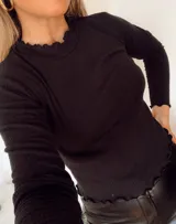 Remera gris de morley de algodón, de manga larga, con terminaciones fruncidas en cuello y mangas.