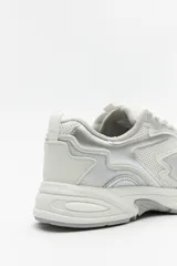 Zapatillas urbanas blancas con detalles plateados, de caña baja y cordones.