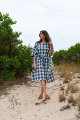 Túnica de corte amplio con estampado de cuadros azules y blancos, cuello redondo y mangas 3/4. Incluye cinturón de la misma tela.