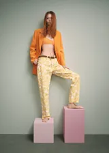 Pantalón de jean recto con estampado de flores amarillas.