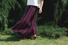 Falda larga color borgoña con finas rayas verticales blancas y cintura elastizada.