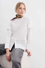 Remera blanca de algodón con mangas largas y calce recto. Diseño de doble capa, con remera de mangas rebatidas y camisa clásica debajo.