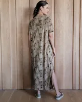 Vestido negro de corte recto, largo midi, con escote en V y mangas cortas.