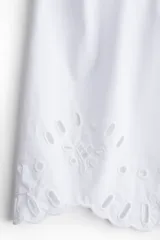 Blusa blanca de algodón con cuello mao y botones. Manga abullonada al codo con broderie tono sobre tono y puños festoneados.