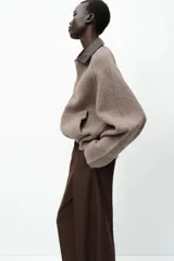 Chaqueta de punto color marrón claro con cuello solapa a contraste en simil cuero color marrón oscuro y manga larga. Cierre frontal con cremallera metálica.