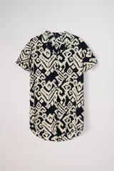 Vestido corto de manga corta y cuello V, con estampado tribal en tonos azul marino y beige claro. Presenta un corte holgado y ruedo redondeado.