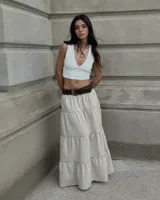 Falda larga color beige, de corte amplio y tiro alto, con diseño escalonado de volantes y cintura elastizada.