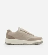 Championes urbanos color beige, confeccionados en material sintético, con recortes laterales, cordones y suela alta con detalles contrastantes.