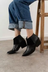 Bota corta de cuero color marrón con paneles de gamuza y cuero texturizado.