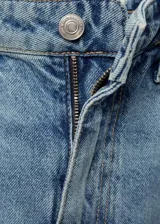 Pantalón de jean celeste de tiro alto, corte balloon, con cinco bolsillos, trabillas y cierre frontal con cremallera y botón.
