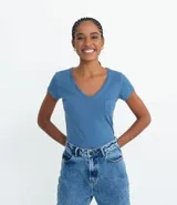 Remera básica celeste de algodón y poliéster, con escote en V, mangas cortas y bolsillo pequeño en el pecho.