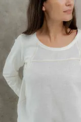 Remera negra de manga larga con costuras decorativas en color ocre en hombros y escote.