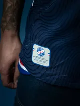 Camiseta de fútbol Umbro del Club Nacional de Football, modelo Away 2025. Diseño azul con detalles en blanco y rojo en cuello y mangas. Incluye logo de Umbro, escudo del club y sponsor Antel en el frente.