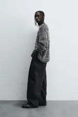 Pantalón de jean negro de corte amplio, estilo balloon fit, con cinco bolsillos y cierre frontal con botones.