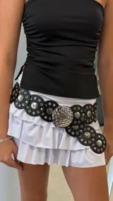 Cinturón negro con apliques circulares plateados y hebilla circular con textura.