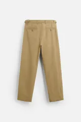 Pantalón chino color beige de corte recto, con cintura ajustable con cordón interior y trabillas laterales. Tiene bolsillos frontales y traseros de vivo.