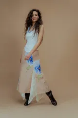 Falda larga color beige con estampado de flores azules y gajos de encaje.