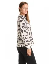 Buzo de hilado fino color blanco con estampado animal print en negro y gris. Cuello redondo, manga larga y detalle de botones dorados en los laterales.