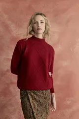 Sweater rojo de tejido de punto con cuello alto y diseño de rombos en el frente.